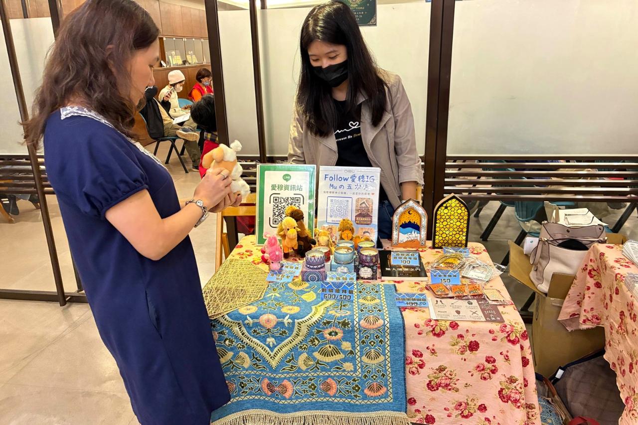 愛穆小組攤位擺出刺繡禮拜毯與駱駝玩偶，向會眾介紹穆斯林文化。本會提供