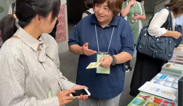 日本宣教士Emily與來往的人分享來自台灣樂果實協會的福音工具「幸福翻翻卡」。樂果實協會提供