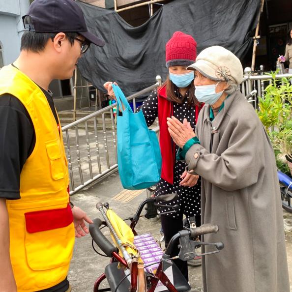 一位長者從文健站志工手中接過物資,臉上露出笑容。
